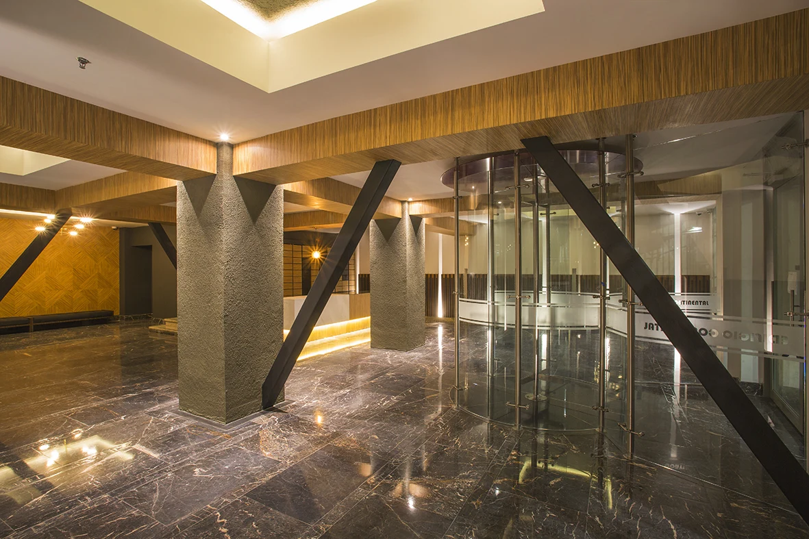 The structural bracing diagonals stay exposed between textured columns